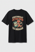 Flat-lay mockup of a black Emotionally Attached to Snacks dragon T-shirt with a compact chest print