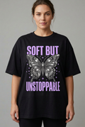 Model wearing a black Soft But Unstoppable butterfly T-shirt with a smaller print